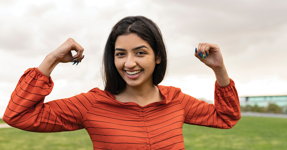 Woman smiling and raising her hands because she learned the truth surrounding myths about alcohol & underage drinking.