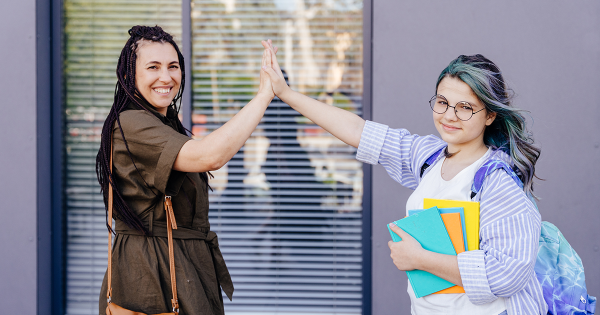 Two teens giving a high five: How to talk to your teen about drug use.