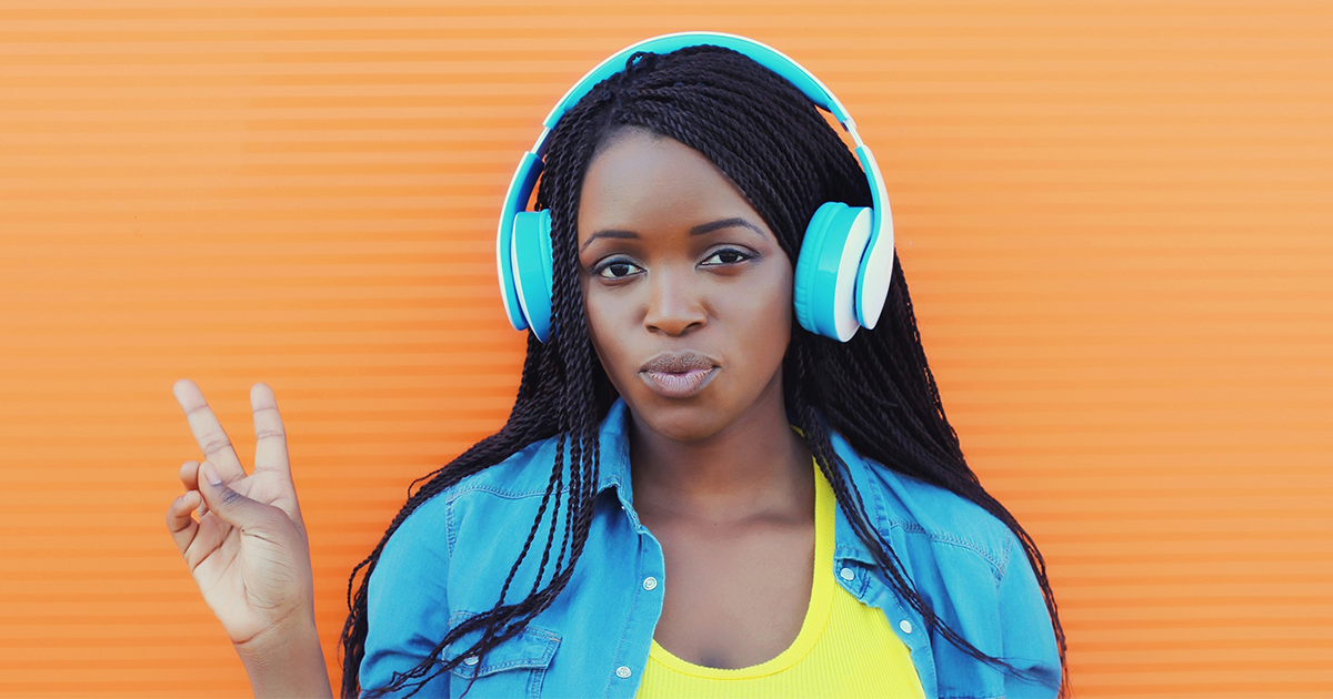 Teen with headphones forming the peace symbol learning to resist peer pressure.