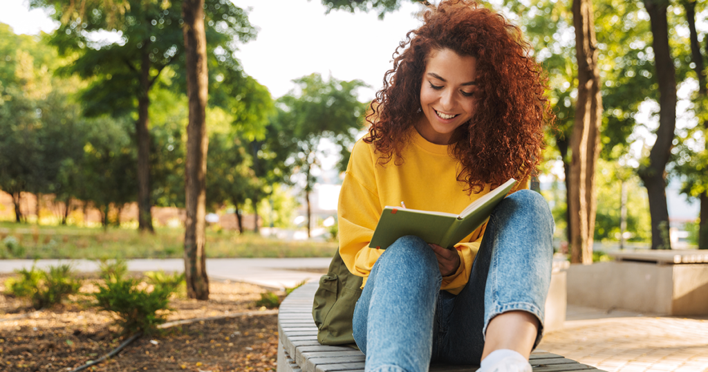 Teen writing in notebook outside learning about teen substance misuse.