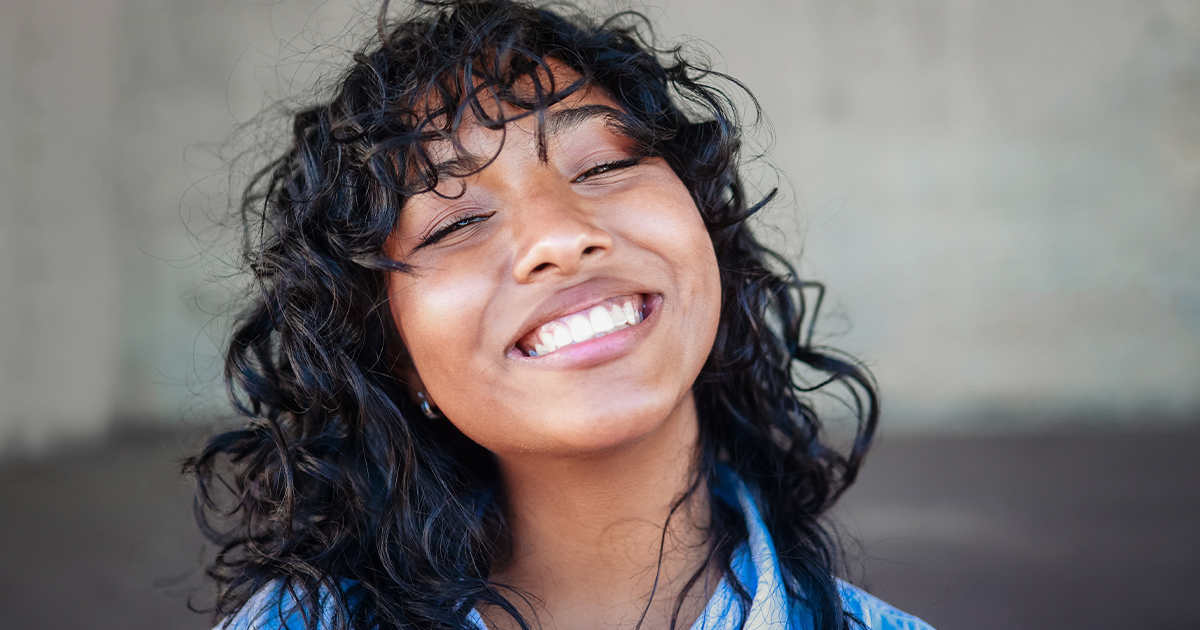 Teen smiling and developing coping mechanisms for stress and anxiety.