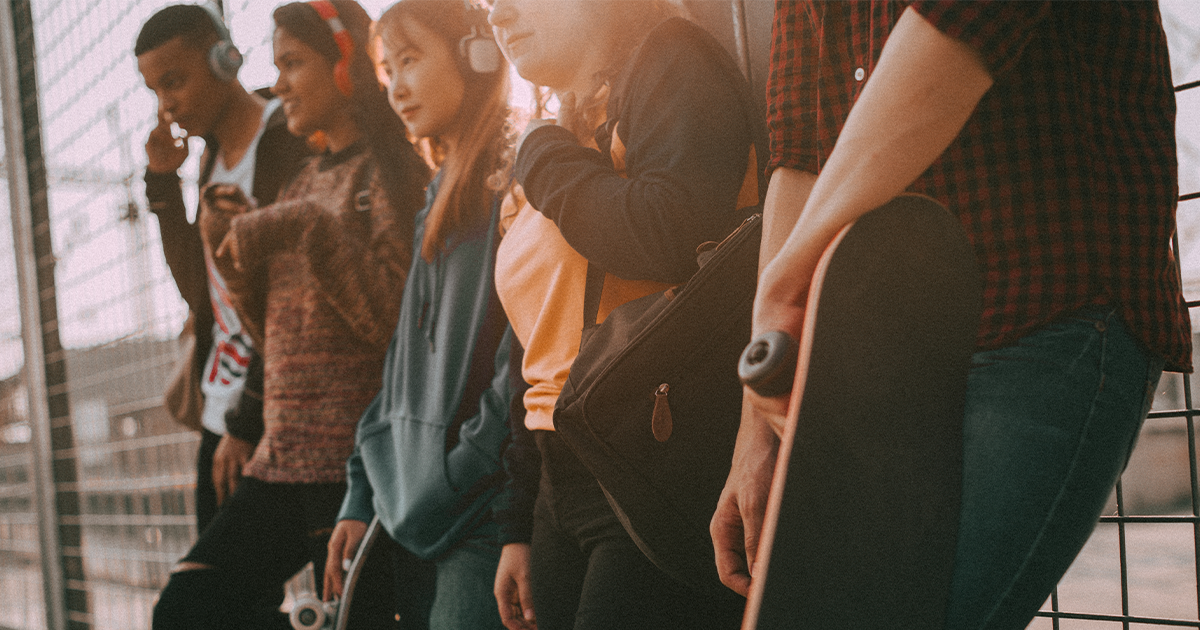 Group of teens standing against a wall building healthy relationships.